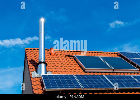 Hausdach mit Sonnenkollektoren, Edelstahl Schornstein, Energiewende Stockfoto