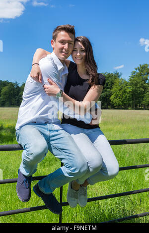 Junger attraktiver Mann umfassenden Frau in der Natur an sonnigen Tag Stockfoto