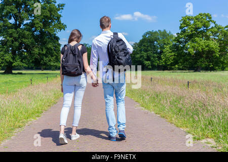 Junger Mann und Frau gehen zusammen auf der Straße in der Natur an sonnigen Tag Stockfoto