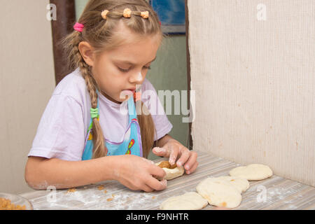 Vierjährige Mädchen bereitet Torten mit Kraut in der Küche Stockfoto