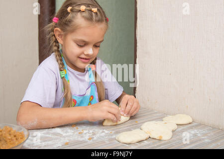 Vierjährige Mädchen bereitet Torten mit Kraut in der Küche Stockfoto