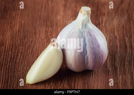 Frischen Kopf von Knoblauch und Nelken auf braunen Holztisch Stockfoto