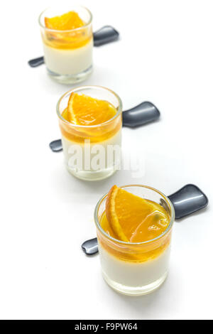 Joghurt Penna Cotta mit Orange und Maracuja Marmelade in Gläser auf weichen Ton Hintergrund Stockfoto