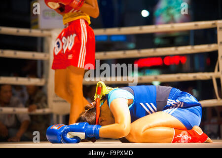 Weibliche Muay thai Kämpfer blau verbeugte sich den Kopf am Ring Leinwand Durchführung eine Kickbox-Ritual namens Wai Khru vor Spiel Stockfoto