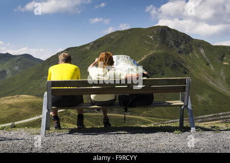 Paar, sitzen auf Bank Frau betrachten Karte im idyllischen Sommer Alpen Berge Landschaft, Saalbach-Hinterglemm Stockfoto