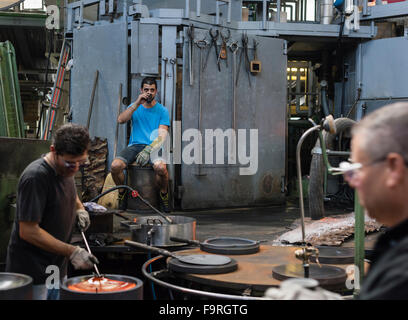 Glasbläser arbeiten vor dem Ofen in der Glashütte Hergiswil, Schweiz, umgehen glühenden, geschmolzene Glas. Stockfoto