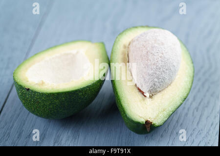 Reife grüne Avocado auf blauen Holztisch Stockfoto