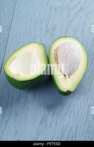 Reife grüne Avocado auf blauen Holztisch Stockfoto