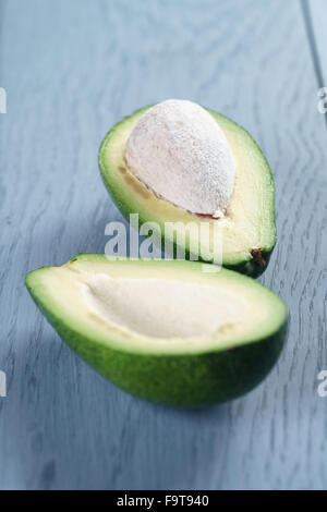 Reife grüne Avocado auf blauen Holztisch Stockfoto