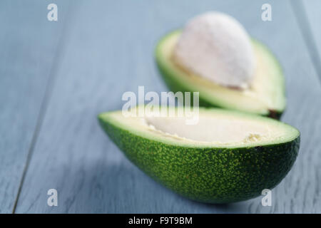 Reife grüne Avocado auf blauen Holztisch Stockfoto