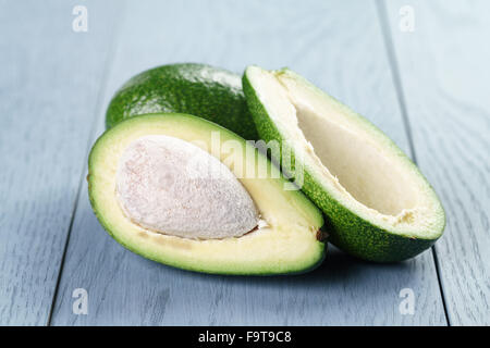 Reife grüne Avocado auf blauen Holztisch Stockfoto