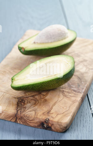 Reife grüne Avocado auf blauen Holztisch Stockfoto