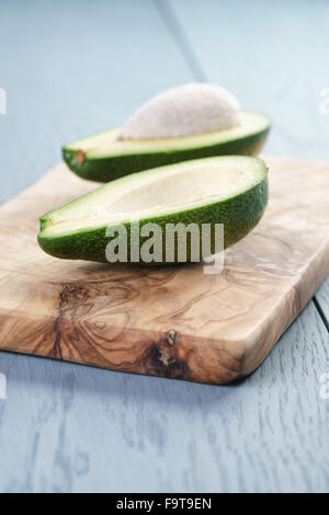Reife grüne Avocado auf blauen Holztisch Stockfoto