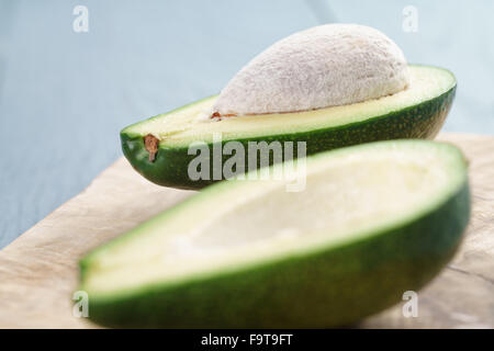 Reife grüne Avocado auf blauen Holztisch Stockfoto