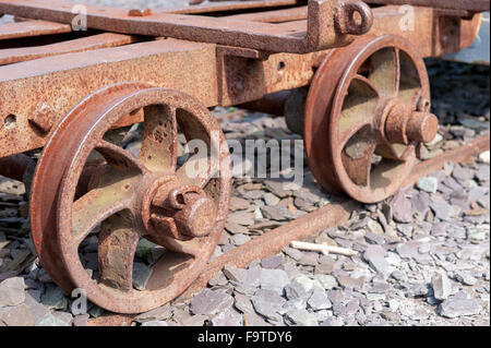 Kleinen rostigen Grubenzug Träger Nahaufnahme von Räder Stockfoto