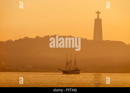 Winter-Sonnenuntergang am Fluss Tejo in Lissabon, Portugal. Suchen in Richtung Christus-König-Statue in Almada. Stockfoto