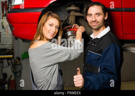 Kfz-Mechaniker und weiblichen Auszubildenden in garage Stockfoto