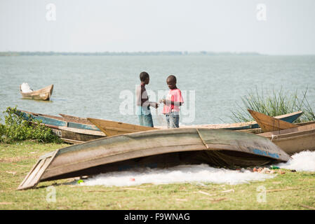 Jungen, die Befestigung der Netze in einem Fischerdorf auf Hütte Kanal, Uganda Stockfoto