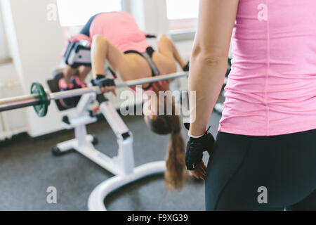 Frau tut gewichtet zurück Erweiterungen im Fitness-Studio Stockfoto