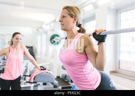 Frau tut gewichtet zurück Erweiterungen im Fitness-Studio Stockfoto