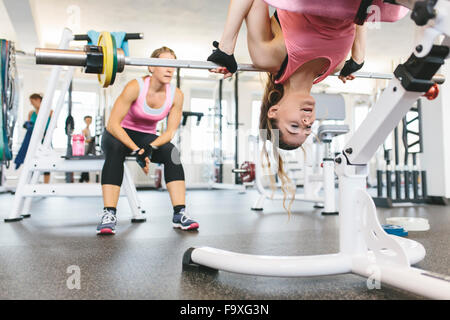 Frau tut gewichtet zurück Erweiterungen im Fitness-Studio Stockfoto