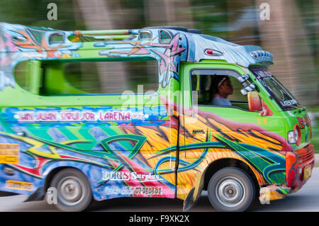 Philippinischen Mann fahren eine sehr bunte Jeepney-Mini-van Stockfoto