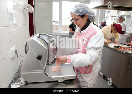 Speisekammer Koch schneidet Sortiment in Scheiben geschnittene Wurst an einem Automaten. Stockfoto