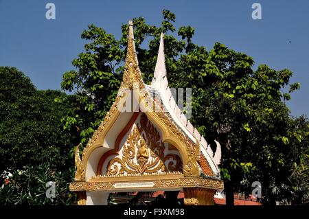 Pattaya, Thailand: Vergoldete Gateway mit Bas-Relief-Design und Aponsi Figur im Wat Chai Mongkons Stockfoto