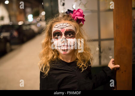 Blondes Mädchen mit Sugar Skull bilden an Halloween Stockfoto