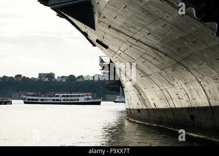 Der Flugzeugträger USS Intrepid. Intrepid Sea, Air & Space Museum mit einer Fähre im Hudson River, New York City, USA Stockfoto