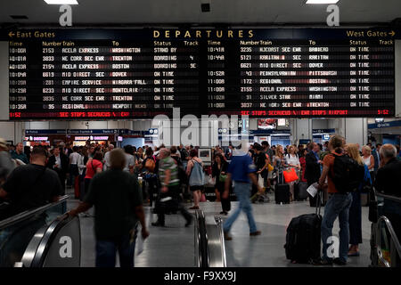 Menschen innerhalb der Penn Station mit Abreise Informationsbildschirm im Hintergrund. Manhattan, New York City, USA Stockfoto