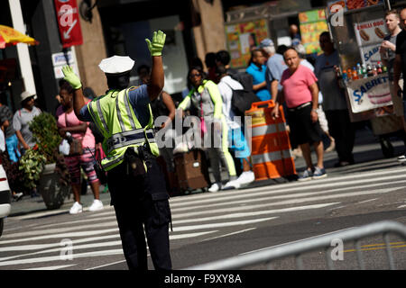 Polizistin regelt den Verkehr in der Nähe von Herald Square in Midtown Manhattan, New York City, USA Stockfoto