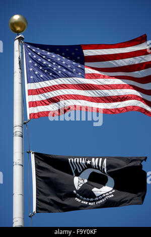 Die Flagge der Vereinigten Staaten über ein Kriegsgefangener fliegen / MIssing in Action-Flagge auf eine Fahnenstange gegen blauen Himmel Stockfoto