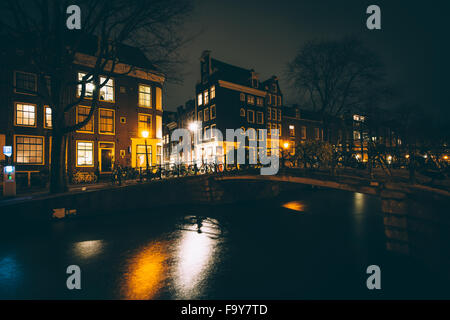 Brücke über einen Kanal in der Nacht in Amsterdam, Niederlande. Stockfoto