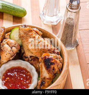 hausgemachte gegrillte Hähnchenflügel in einer Holzschale mit Thai chill süßen Soße Stockfoto
