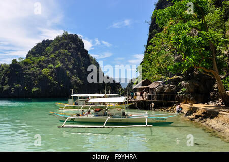 Traditionelle philippinische Holzboote in einer blauen Lagune im tropical island Stockfoto