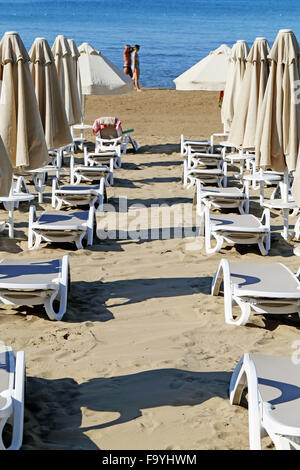 Schöne Liegestühle mit Sonnenschirmen am Strand Stockfoto