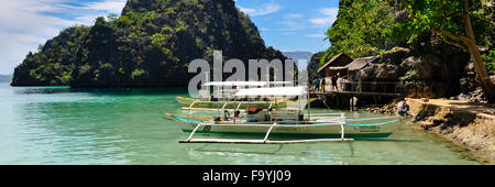 Traditionelle philippinische Holzboote in einer blauen Lagune im tropical island Stockfoto