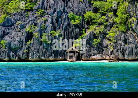 Einsame Holz Bambushaus auf Stelzen an einem kleinen versteckten Strand der Felseninsel Stockfoto