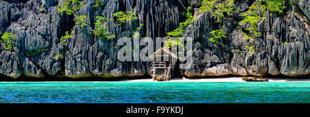 Einsame Holz Bambushaus auf Stelzen an einem kleinen versteckten Strand der Felseninsel Stockfoto