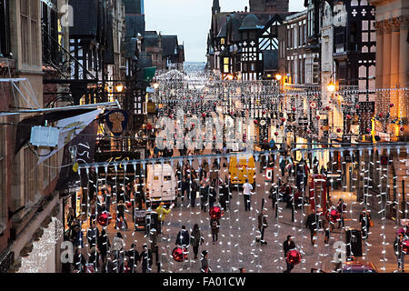 Straßenszene von Chester England mit Weihnachtsbeleuchtung und Menschen beim Einkaufen Stockfoto