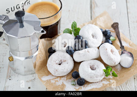 Pulverisierter Zucker Donuts auf Pergament mit Blaubeeren und Minze Stockfoto