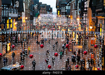 Straßenszene von Chester England mit Weihnachtsbeleuchtung und Menschen beim Einkaufen Stockfoto