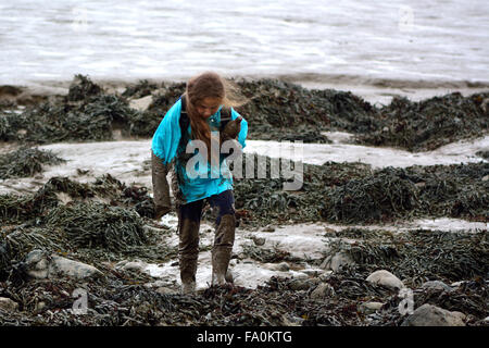 Kinder, die im Schlamm auf felsigen Strand bedeckt 