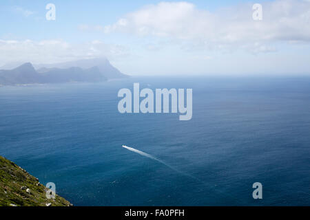 Ein Motorboot in den Atlantischen Ozean in der Nähe von Cape Point in Südafrika, mit Bergen im Hintergrund Stockfoto