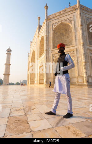 Eine nicht identifizierte Rajasthani indische Mann im langen weißen Kurta Shirt, red Hat und große Schnurrbart draußen auf den weißen marb Stockfoto