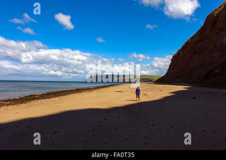 Einsame Figur auf Skinningrove Strand, Goldstrand und blauen Himmel, North Yorkshire Stockfoto