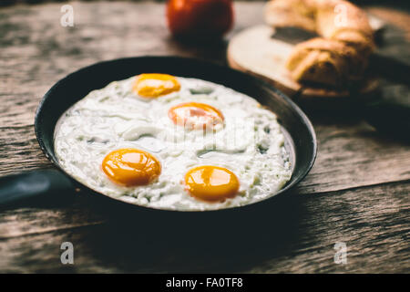 Spiegeleier in einer Pfanne auf einem Holztisch Stockfoto