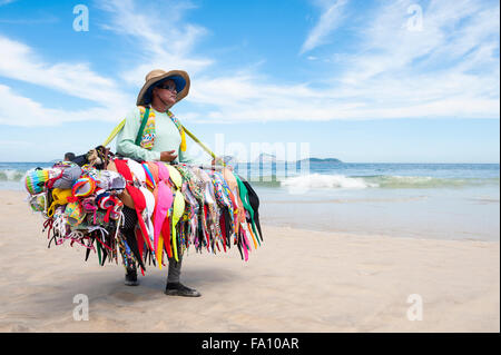 RIO DE JANEIRO, Brasilien - 15. März 2015: Ein Strand-Verkäufer verkaufen Bikinis trägt ihre Ware Ipanema Strand entlang.