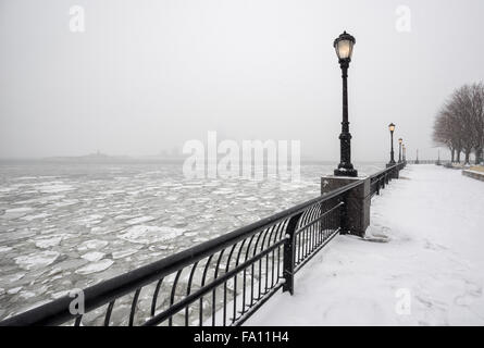 Hudson River vom verschneiten Battery Park in Richtung Jersey City in Nebel eingefroren. Ein stiller Wintertag in New York City Stockfoto